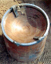 Improvised explosive device in Iraq. The concave copper shape on top defines an explosively formed penetrator/projectile. Improvised explosive device explosively formed penetrator Iraq.jpg