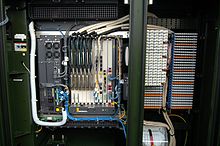 Inside an FTTN or FTTC fiber cabinet. The left side contains the fiber and a DSLAM, and the right side contains the copper and punch down blocks for a form of DSL such as VDSL Inside fibre cab (12945979503).jpg