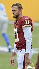 Man holding football helmet by the facemask