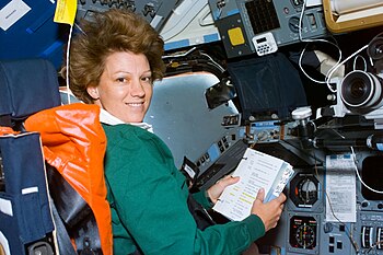 Eileen Collinsová na misi STS-93 raketoplánu Columbia, při níž se v červenci 1999 stala historicky první ženskou velitelkou programu Space Shuttle. Již na misi STS-84 jako první žena pilotovala raketoplán.