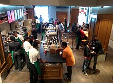 A typical retail area, this one in Bangalore, India, showing a display of food and the beverage preparation area Starbucks Bangalore (11450307004).jpg