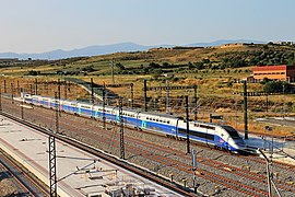 TGV arribant a l'estació de Figueres-Vilafant. Darrere, al turó de la dreta, el Castell de Sant Ferran