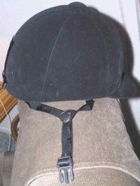 A modern ASTM/SEI show-legal helmet covered in velveteen to resemble the old style hunt cap, but has visibly more protective material and an attached harness VelvetHelmet.jpg