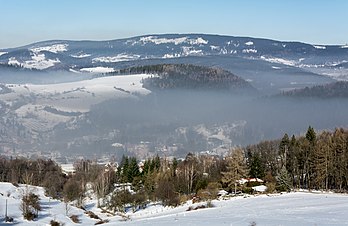 Smog de inverno sobre Nowa Ruda, Polônia, um tipo de poluição atmosférica intensa. A palavra "smog" foi cunhada no início do século XX e é uma contração das palavras inglesas smoke (fumaça) e fog (nevoeiro) para se referir ao nevoeiro esfumaçado devido à sua opacidade e odor. Este tipo de poluição do ar visível é composto por óxidos de nitrogênio, óxido de enxofre, ozônio, fumaça e outras partículas. O smog produzido pelo homem é derivado de emissões de combustão de carvão, emissões veiculares, emissões industriais, incêndios florestais e agrícolas e reações fotoquímicas dessas emissões. O smog de verão está principalmente associado à formação fotoquímica do ozônio. Durante a temporada de verão, quando as temperaturas são mais quentes e há mais luz solar presente, o smog fotoquímico é o tipo dominante de formação de smog. Durante os meses de inverno, quando as temperaturas são mais frias e as inversões térmicas são comuns, há um aumento no uso de carvão e outros combustíveis fósseis para aquecer casas e edifícios. Estas emissões de combustão, juntamente com a falta de dispersão de poluentes sob inversões, caracterizam a formação de smog de inverno. (definição 4 551 × 2 958)