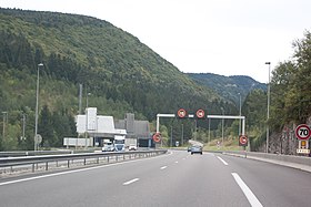 Vue depuis l'A40 de l'entrée sud du tunnel de Chamoise dominée par la montagne.