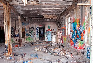 Photograph of the inside of an abandoned building with prolific graffiti covering the walls