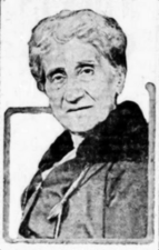 A black and white photograph of the head and shoulders of a woman