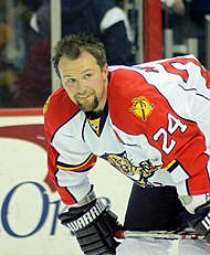 Bryan McCabe in a red and white Florida Panthers jersey, bending forward and looking to the right