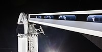 Корабель на верхівці Falcon 9 перед стартом. Видно перехідний місток від пускової вежі для входу астронавтів