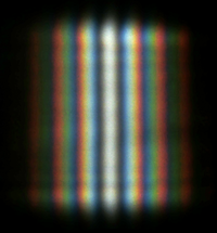 A double-slit interference of the sunlight passing through two slits ~1 cm long and ~0.5 mm apart. At the top and the bottom of the image the interference on the edge of the slit produces noticeable variation of the brightness.