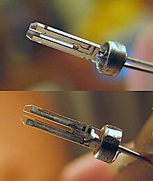 Picture of a quartz crystal resonator, used as the timekeeping component in quartz watches and clocks, with the case removed. It is formed in the shape of a tuning fork. Most such quartz clock crystals vibrate at a frequency of 32768 Hz. Inside QuartzCrystal-Tuningfork.jpg