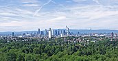 Der Frankfurter Stadtwald grenzt südlich an die städtische Bebauung Frankfurts an. Im Vordergrund ein Teil des „Oberwaldes“, Ansicht von Südosten. Dahinter die auch „Mainhattan“ genannte Frankfurter Skyline sowie am Horizont der Mittelgebirgszug Taunus.