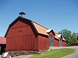 Stora logen/förrådsbyggnaden, med gårdsklocka på taknocken.