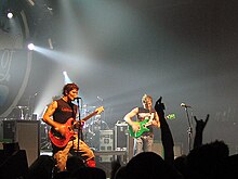 Two people playing guitar onstage