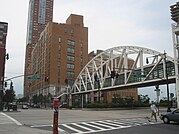 View of the Tribeca Bridge, a pedestrian bridge, from the southeast corner of Chambers and West Streets. The bridge connects the east side of West Street to Stuyvesant High School on the street's west side.