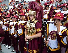 The drum major of the Spirit of Troy wears a more elaborate uniform and conducts the band with a sword. 2008-0830-USC-UVA-TMB-drummajor.jpg