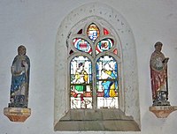 Chapelle Saint-Hervé, deux statues (dont celle de saint Budoc) de part et d'autre d'un vitrail.