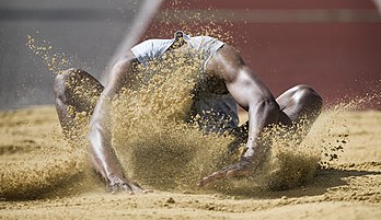 Um atleta de salto em distância do Exército aterrissa na areia na Competição de Atletismo Inter-Corps, estádio de atletismo Tidworth Oval em Tidworth, Wiltshire, Inglaterra (definição 2 406 × 1 388)