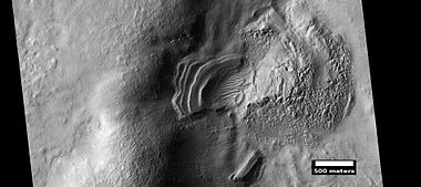 Layered feature that is probably the remains of a once widespread unit that fell from the sky, as seen by HiRISE under the HiWish program. Dipping layers are common in some regions of Mars. They may be the remains of mantle layers. Another idea for their origin was presented at 55th LPSC (2024) by an international team of researchers. They suggest that the layers are from past ice sheets.[52]
