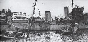 HMS Vivacious at Dunkirk, France, in late May 1940 during Operation Dynamo. A sunken ship is in the foreground. HMS Vivacious at Dunkirk.jpg