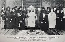 Pope Pius XI in an audience with Demetrius I Qadi, Patriarch of Antioch and All the East and other bishops of the Melkite Greek Catholic Church in 1923 Pius XI with Patriarch of the Melkite Greek Catholic Church.jpg