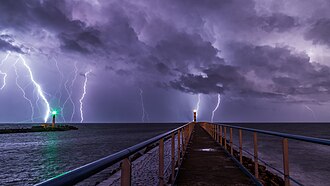 Strokes of cloud-to-ground lightning strike the Mediterranean Sea off of Port-la-Nouvelle in southern France. Port and lighthouse overnight storm with lightning in Port-la-Nouvelle.jpg