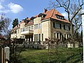 Villa mit Terrassenbalustrade, Einfriedung und Garten