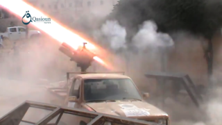 Lansator multiplu al Legiunii Sham, montat pe un vehicul cu blindaj ușor, lansează rachete împotriva pozițiilor YPG din Alep, pe 2 octombrie 2015.