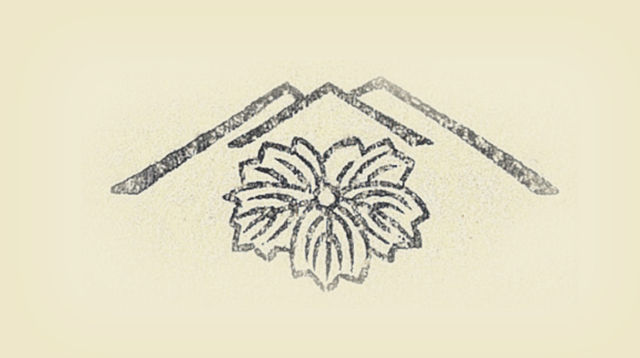 A publisher's seal in the shape of a flower within a stylized mountain