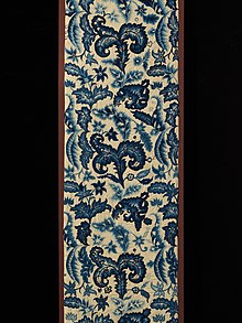 This curtain panel is worked in crewel embroidery in shades of blue. The design is a variety of types of stylized leaves.