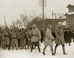 Tallinnaan saapunut I Suomalaisen Vapaajoukon 1. komppania marssimassa satamasta paraatiin Pietarintorille 30.12.1918. Keskellä komentaja Martin Ekström, oikealla tulkki-adjutantti Elmar Kirotar ja taaempana komppanian päällikkö Anto Eskola.[1]