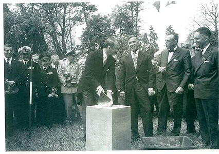 The cornerstone of the first building being placed by James M. Gavin, with Mayor Jean Masselin of Sainte-Mère-Église at far right, June 6, 1962