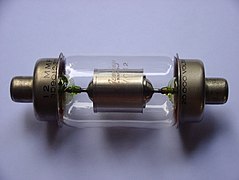 Vacuum capacitor with uranium glass encapsulation