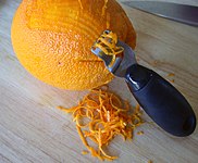 Zesteur en action sur une orange.