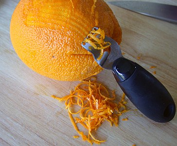Herstellung von Orangen-Zesten, mit Hilfe eines Zesten­reißers