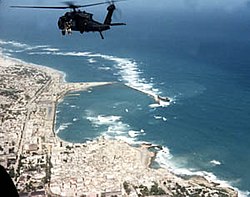 מסוק UH-60 בלק הוק שסימנו סופר 4–6 מרחף מעל חוף מוגדישו.