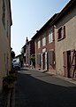 Vu de la rue latérale, la maison est au premier plan à droite.