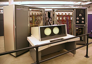 The CDC 6600. Behind the system console are two of the "arms" of the plus-sign shaped cabinet with the covers opened. Individual modules can be seen inside. The racks holding the modules are hinged to give access to the racks behind them. Each arm of the machine had up to four such racks. On the right is the cooling system. CDC 6600.jc.jpg