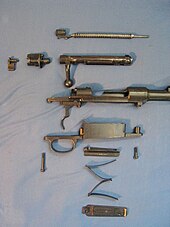 A disassembled Mauser action showing a partially disassembled receiver and bolt Disassembled mauser long action.jpg