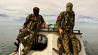 Anarchist IRPGF fighters ferrying supplies across Lake Assad