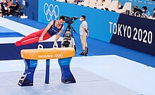 Ginasta armênio Artur Davtyan competindo em uma prova de ginástica olímpica nas Olimpíadas de Tokyo 2020.