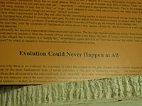 A poster details arguments against evolutionism and concludes "Evolution Could Never Happen at All."