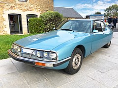 Superbe Citroën SM dans sa livrée "bleu platine", une des sept teintes métallisées disponibles à l'époque pour cette routière de luxe à la française. Les six autres coloris métallisés étant le "blanc cygne", le "rouge Brasilia", le "gris nacré", le "sable métallisé", le "feuille dorée" et le "vert des Tropiques".