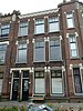 Boven- en benedenwoning, onderdeel van een blok van acht beneden- en bovenwoningen in art-nouveaustijl.