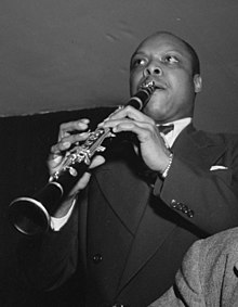 Ben Webster, Eddie Barefield, Buck Clayton kaj Benny Morton dum prezentado en la ĵazklubejo Famous Door, Novjorko, proks. oktobron de 1947. Foto de William P. Gottlieb