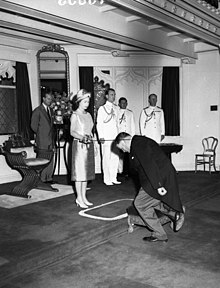 Elizabeth II knights an individual during her 1963 visit to Australia Investiture, Royal visit of Queen Elizabeth II and the Duke of Edinburgh, February 1963, Government House, Sydney - photographer Australian Photographic Agency (7300133560).jpg