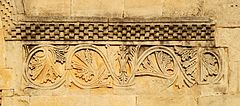 Frise en damier et rinceaux ornant le portail du prieuré Notre-Dame de Salagon.