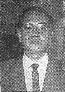 Black-and-white portrait of Sujono Hadinoto wearing a suit-and-tie with glasses