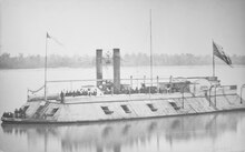 black-and-white photograph of a ship with metal-plated sides, with cannons sticking out the sides and two smokestacks above
