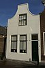 Huis met gepleisterde tuitgevel met stoep